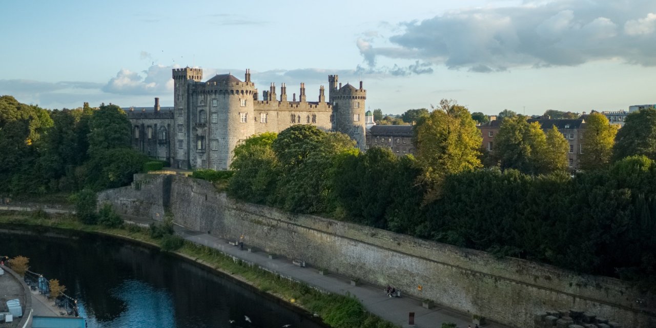Kilkenny Castle and Gardens by a river 