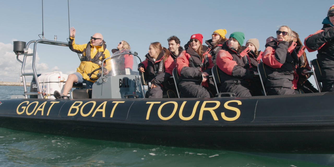 Group of people on a boat looking into the distance 