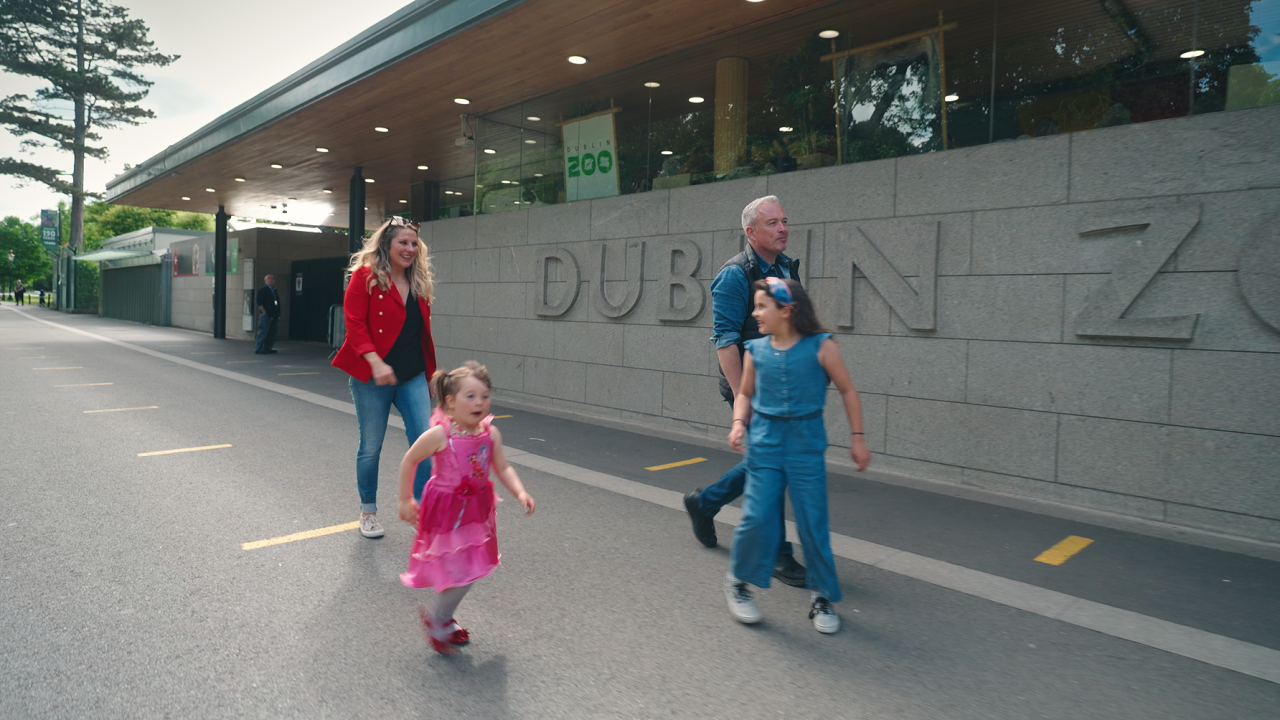 a family of four walking passed dublin zoo a man woman and their two children walking outside dublin zoo