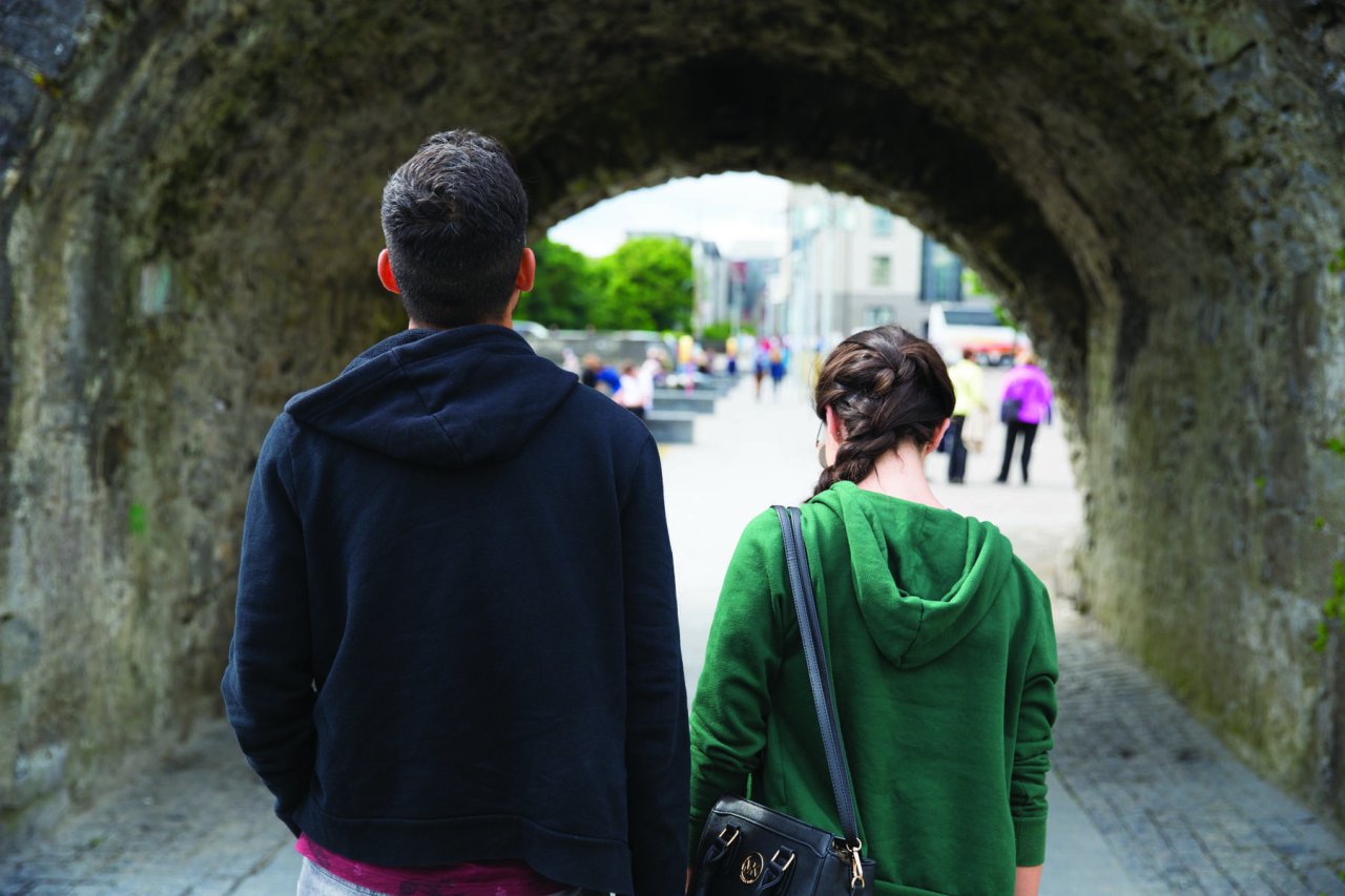 couple walking under spanish arch