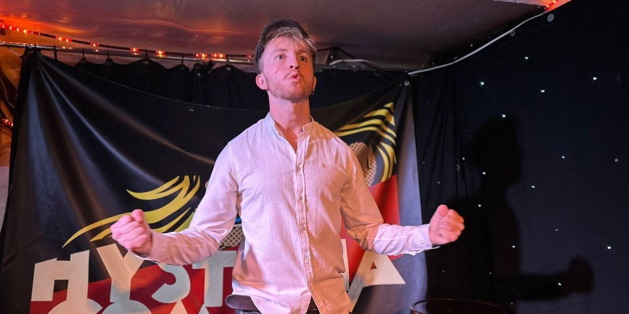 Man standing on stage expressing himself